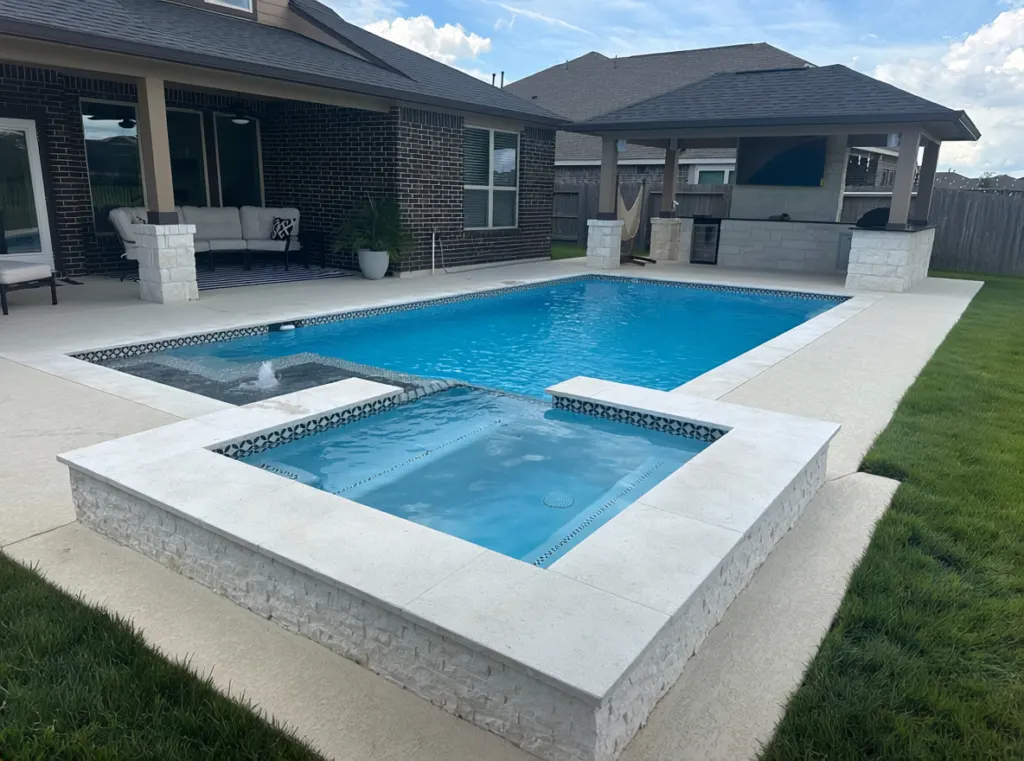 Pool and raised spa with outdoor living area built by Mango Pool & Spa in Baytown, TX